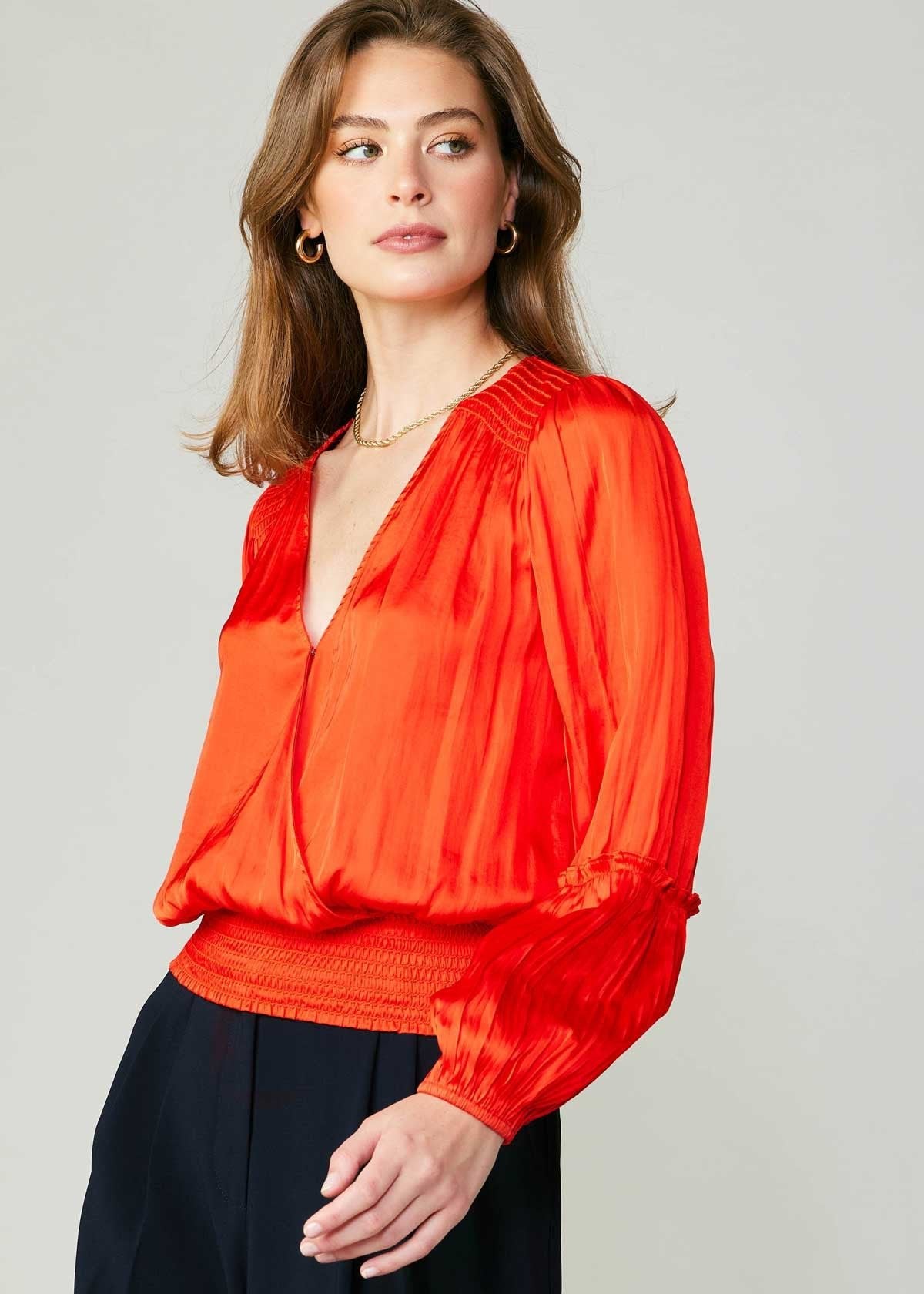 Flame long sleeve neck blouse with pleated detail on sleeve and smocked detail on hem and shoulder.