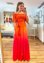Load image into Gallery viewer, Orange fuchsia printed woven maxi dress featuring off shoulder neckline with ruffled edge, smocked bodice with self sash tie and ruffled hemline.
