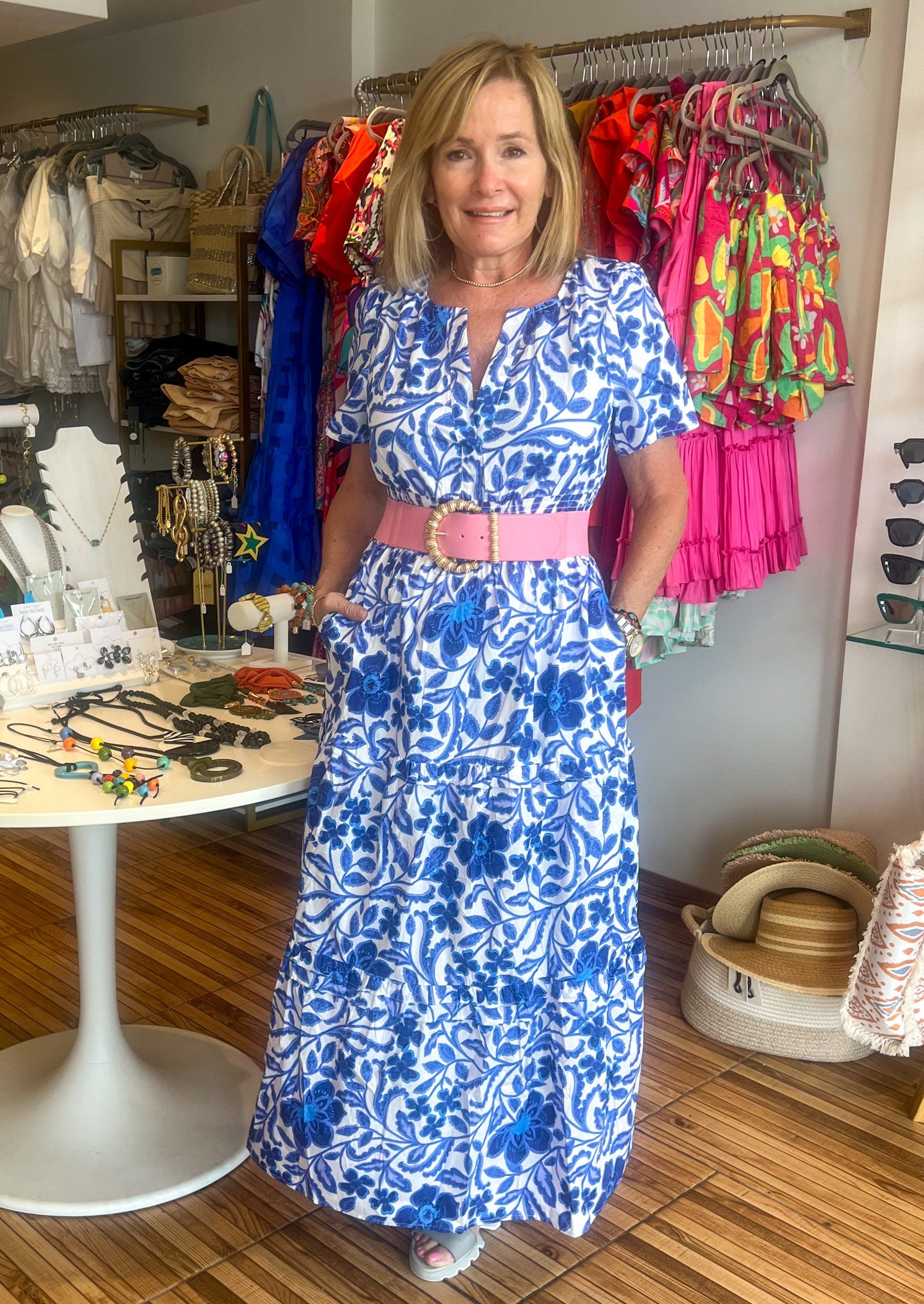 Celeste Floral Palmer Poplin Tiered Maxi Dress! It features billowed short sleeves that frame a split neckline where it meets a smocked waistline. Side pockets sit at the seam of a ruffle tiered midi skirt.