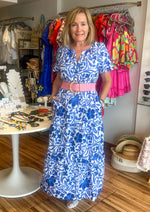 Load image into Gallery viewer, Celeste Floral Palmer Poplin Tiered Maxi Dress! It features billowed short sleeves that frame a split neckline where it meets a smocked waistline. Side pockets sit at the seam of a ruffle tiered midi skirt.
