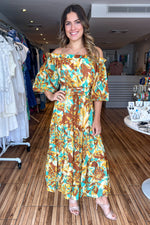 Load image into Gallery viewer, Brown mint printed woven midi dress featuring off shoulder neckline with ruffled edge, 3/4 sleeve, smocked waistband with front lace up toe detail and tiered skirt.
