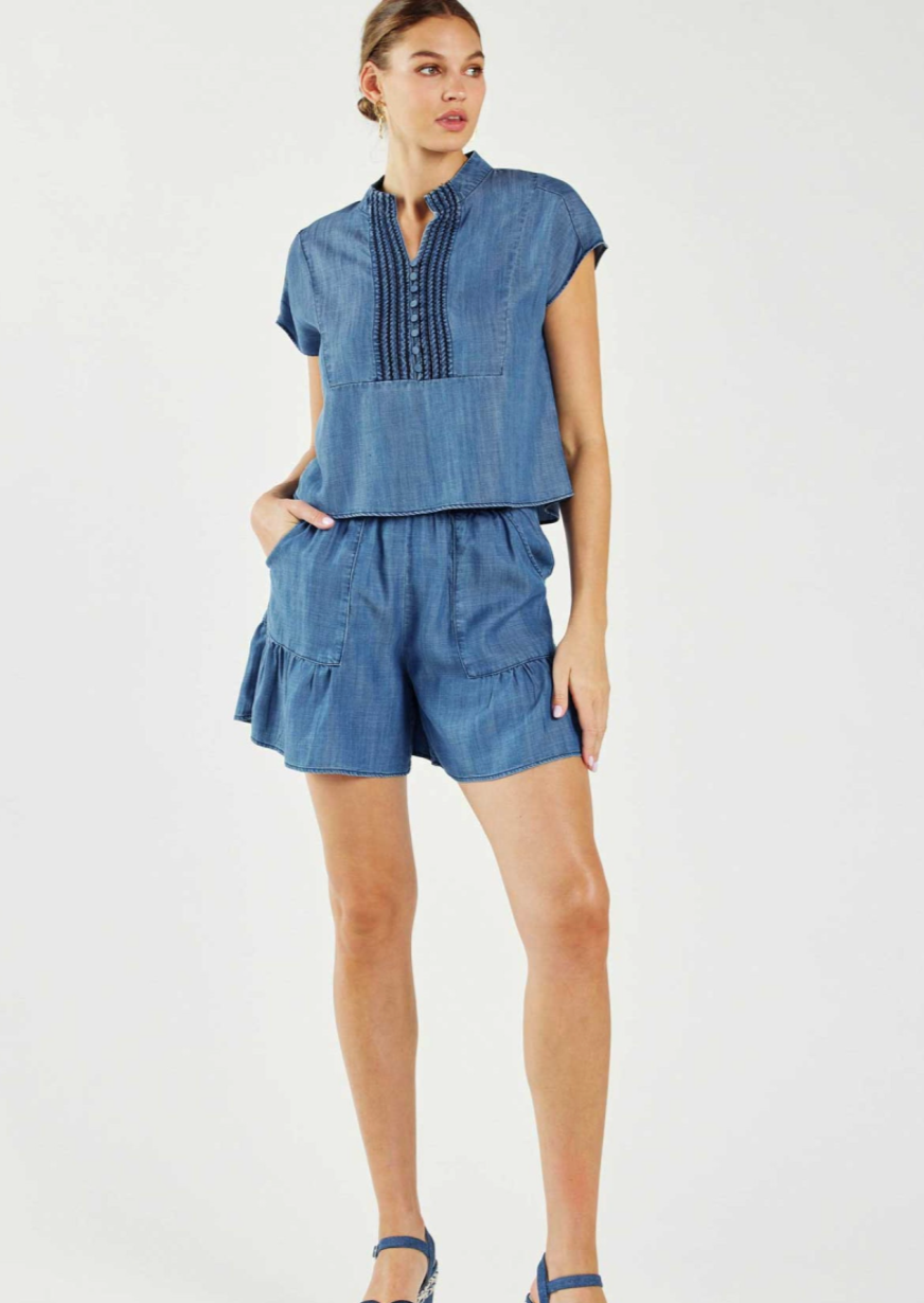 Chambray two piece set. Chambray elastic waisted tiered shorts with side pockets with short sleeve boxy-cut top with button front detail.