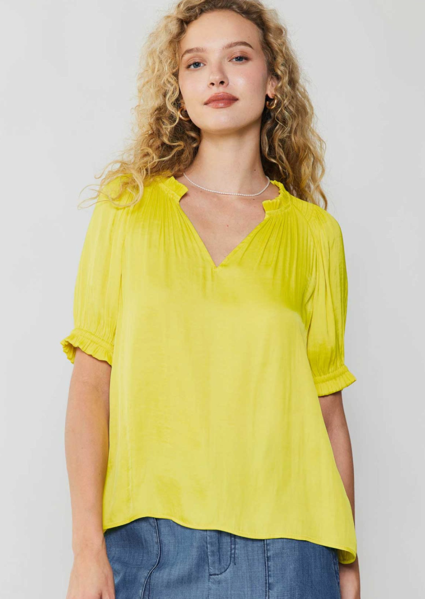 Pineapple short sleeve v-neck blouse with smocked detail on shoulder and ruffle detail on neck and cuff.