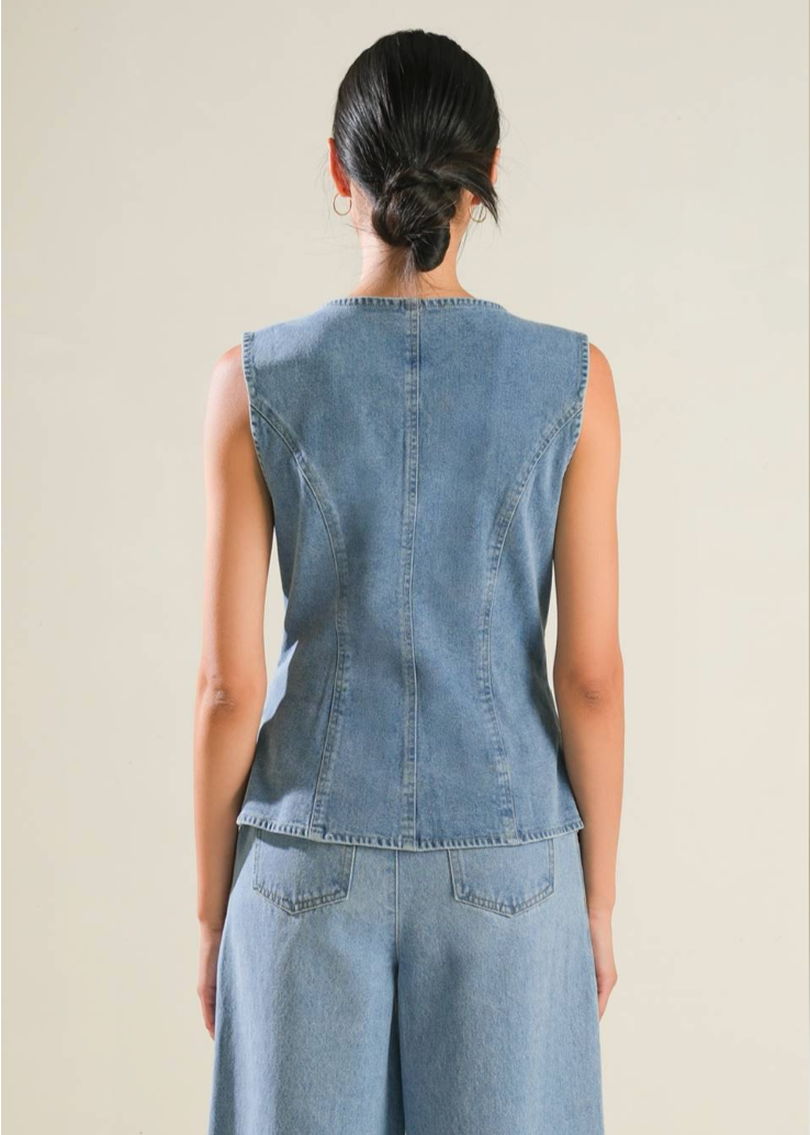 A washed denim vest featuring round neckline, button down and side pockets.