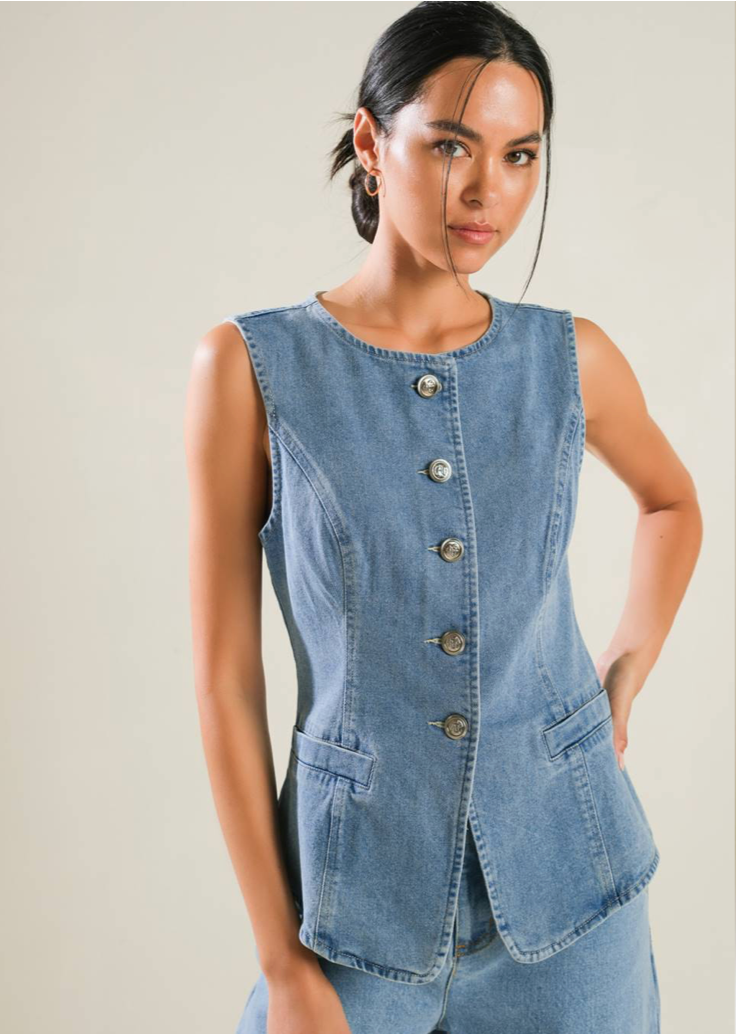 A washed denim vest featuring round neckline, button down and side pockets.