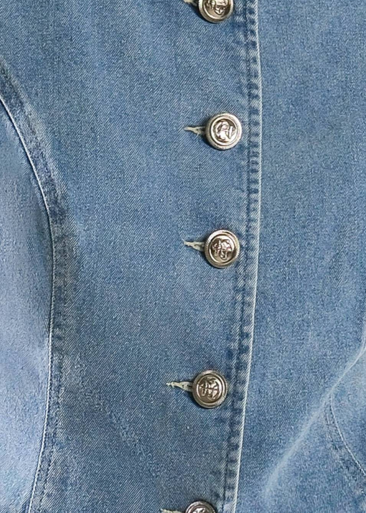 A washed denim vest featuring round neckline, button down and side pockets.