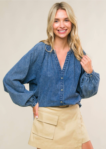 An acid washed denim top with round neckline, long raglan sleeve and button down